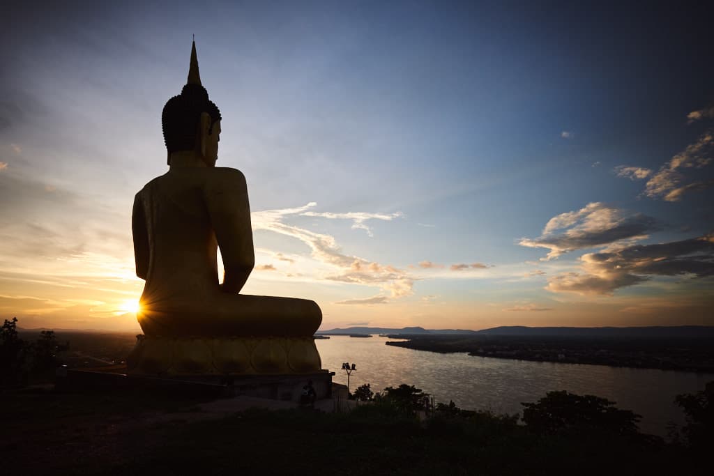 Andächtig betrachtet der Buddha den Sonnenuntergang über Pakse