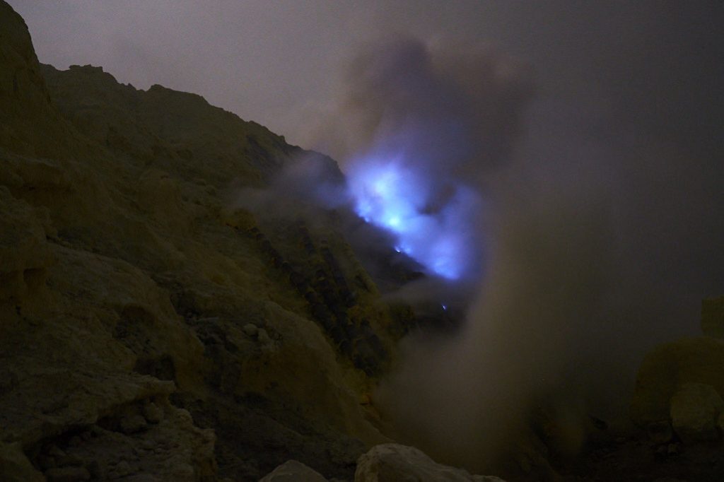 Blaue Flammen lodern aus der Kraterwand des Ijen